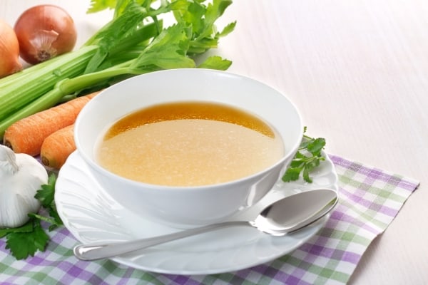 Bowl of broth and fresh vegetables