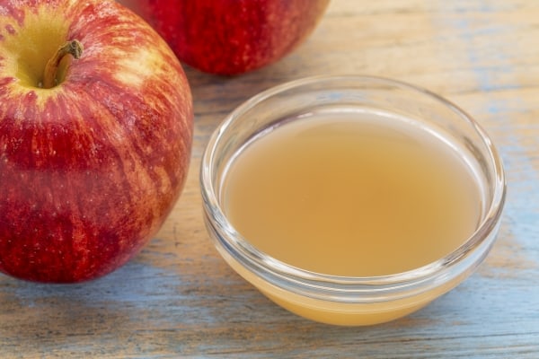 Unfiltered apple cider vinegar andh fresh red apples