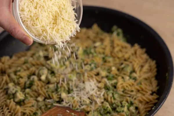 Adding grated parmesan to pasta