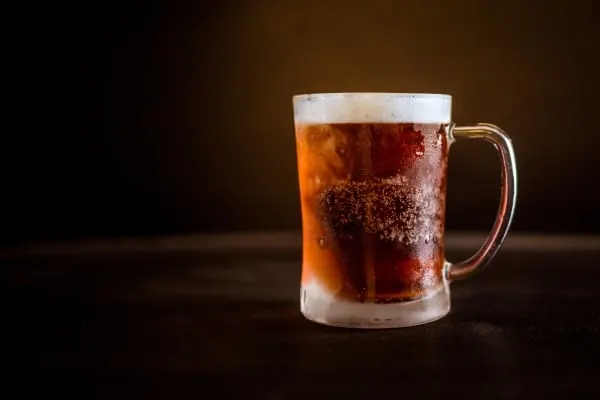 Cold beer in a clear glass mug