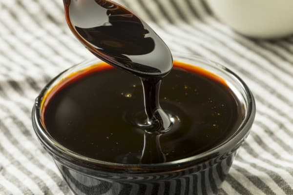 Black Molasses in a Bowl and a Spoon