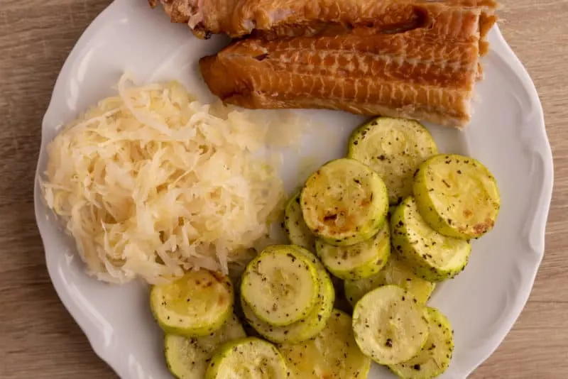 Cooked zucchini, sauerkraut and smoked fish