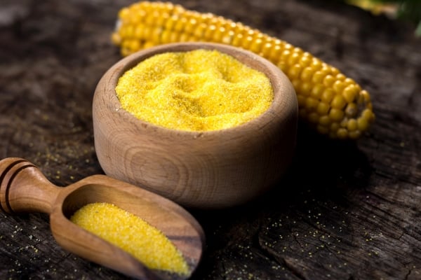 Cornmeal in a wooden bowl and scoop