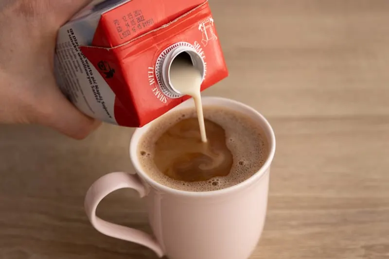 Pouring soy milk in coffee