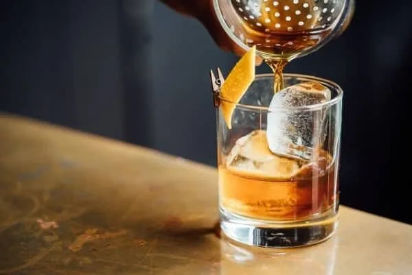 Pouring whiskey on ice cubes