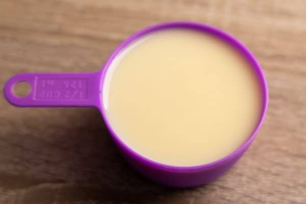 Sweetened condensed milk in a measuring cup