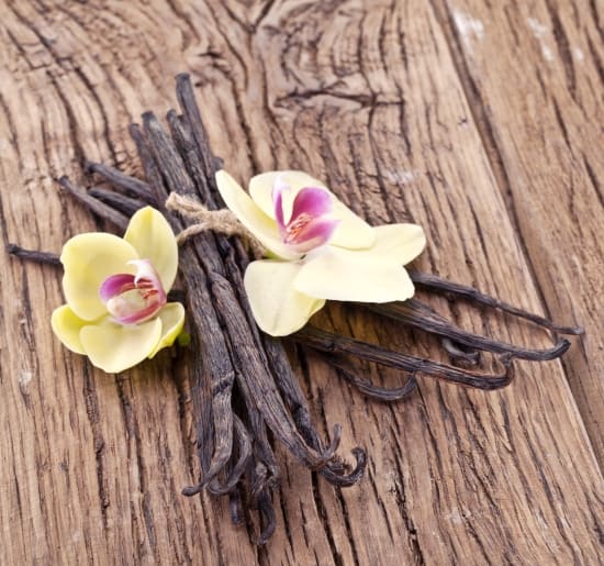 Vanilla sticks with a flower on a wooden table