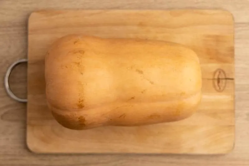 Whole butternut squash on a cutting board